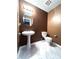 Powder room featuring modern pedestal sink and toilet, complemented by stylish marble-look flooring at 8838 Seneca Rd, Palmetto, GA 30268
