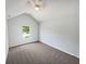 This bedroom features neutral carpeting, a ceiling fan, vaulted ceiling, and a view to the outside at 2226 Exchange Se Pl, Conyers, GA 30013