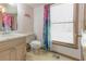 The cozy bathroom features a toilet, window, vanity, and fun floral shower curtain at 730 Ponderosa Ct, Fayetteville, GA 30214