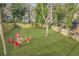 Aerial view of a backyard with fire pit and red adirondack chairs, surrounded by lush greenery and a fence at 1995 Meador Ave, Atlanta, GA 30315