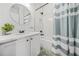 Cozy bathroom featuring white vanity with a round mirror and a tub with striped shower curtains at 1995 Meador Ave, Atlanta, GA 30315
