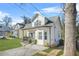 Side view of the charming two-story home showing the manicured lawn and corner of the front porch at 1995 Meador Ave, Atlanta, GA 30315