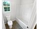 Bright bathroom featuring a shower-tub combo and a window for natural light at 509 Carlton Pointe Dr, Palmetto, GA 30268