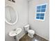 Clean bathroom with a pedestal sink, toilet, and a window at 509 Carlton Pointe Dr, Palmetto, GA 30268