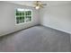 Spacious bedroom with neutral carpet, ceiling fan, and large bright windows overlooking the lawn at 509 Carlton Pointe Dr, Palmetto, GA 30268
