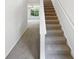 Carpeted staircase leading upstairs with a view of the living area through a window at 509 Carlton Pointe Dr, Palmetto, GA 30268