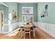 Elegant dining room with wainscoting, a large window, modern lighting, and a farmhouse-style table at 1585 Lake Dow Rd, Mcdonough, GA 30252