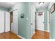 Hallway with hardwood floors, green walls, white doors, and a small basketball hoop at 1585 Lake Dow Rd, Mcdonough, GA 30252