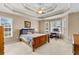 Bright bedroom features a tray ceiling, a ceiling fan, and a large window with natural light at 1585 Lake Dow Rd, Mcdonough, GA 30252