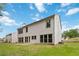 Back exterior view of home, showing many windows and a patio overlooking a grassy yard at 1931 Abinger Way, Lawrenceville, GA 30043