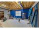 Partially finished basement with carpet, blue accent wall, and some storage shelving at 604 Clearwater Ct, Mcdonough, GA 30252