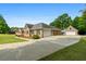 Brick home with a spacious driveway leading to a detached garage at 604 Clearwater Ct, Mcdonough, GA 30252