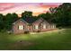Dusk view of a brick home with green lawn at 604 Clearwater Ct, Mcdonough, GA 30252