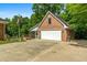 View of the brick garage with an attached screened-in porch and a concrete driveway at 604 Clearwater Ct, Mcdonough, GA 30252