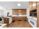 Traditional kitchen with wood cabinets, white countertops and appliances, and hardwood floors at 604 Clearwater Ct, Mcdonough, GA 30252
