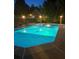 Well-lit in-ground pool with lounge chairs in the backyard at night at 604 Clearwater Ct, Mcdonough, GA 30252