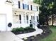Up close view of a white house with landscaped flower beds and black mulch, complemented by a winding walkway at 6265 Lake Windsor Pkwy, Buford, GA 30518