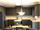 Modern kitchen boasts dark cabinetry, stainless steel appliances, tiled backsplash, and a marble countertop island at 6265 Lake Windsor Pkwy, Buford, GA 30518