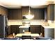 Modern kitchen featuring stainless steel appliances, sleek countertops, and dark cabinets with stylish backsplash at 6265 Lake Windsor Pkwy, Buford, GA 30518