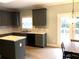 Bright kitchen with granite countertops, stainless steel appliances, and dark cabinets, with doors to the backyard at 6265 Lake Windsor Pkwy, Buford, GA 30518