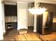 Bright kitchen featuring stainless steel appliances, dark cabinets, and a stylish chandelier above the dining area at 6265 Lake Windsor Pkwy, Buford, GA 30518
