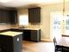 Well-lit kitchen featuring granite countertops, stainless appliances, dark cabinets, and natural light at 6265 Lake Windsor Pkwy, Buford, GA 30518