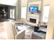 Bright living room with tall windows, fireplace, TV, and a view into the kitchen, perfect for entertaining at 6265 Lake Windsor Pkwy, Buford, GA 30518