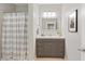 Well-lit bathroom featuring a vanity with a framed mirror and a shower with a striped curtain at 44 Kingsford Xing, Acworth, GA 30101