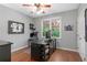 Well-lit office with a large desk, ceiling fan, and window overlooking the backyard at 44 Kingsford Xing, Acworth, GA 30101