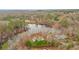 Beautiful aerial view featuring a home surrounded by lush greenery and a serene lake at 8160 Stone Hill Rd, Cumming, GA 30028