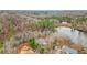 Breathtaking aerial view of home with lake, surrounded by trees, offering privacy and nature at 8160 Stone Hill Rd, Cumming, GA 30028