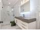 Modern bathroom featuring gray and white tile, a sleek vanity, and a glass-enclosed shower at 8160 Stone Hill Rd, Cumming, GA 30028