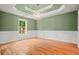 Elegant dining room featuring a tray ceiling, wainscoting, hardwood floors, and a chandelier at 8160 Stone Hill Rd, Cumming, GA 30028