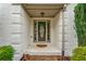 Inviting front porch featuring a decorative glass front door, classic brick detailing, and manicured landscaping at 8160 Stone Hill Rd, Cumming, GA 30028