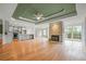 Open living space with hardwood floors, stone fireplace, trey ceiling, and a modern kitchen with a central island at 8160 Stone Hill Rd, Cumming, GA 30028