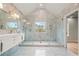 Modern bathroom with an oversized glass shower, double shower heads, and gorgeous stone accent wall and herringbone floor tiles at 8160 Stone Hill Rd, Cumming, GA 30028
