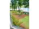 View from window of the backyard with mulch ground covering, trees, plants, and lake with a dock at 312 Flat Shoals Church Rd, Stockbridge, GA 30281