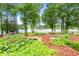 Scenic backyard featuring pond with water lilies, rock border, mulch and view of the lake beyond at 312 Flat Shoals Church Rd, Stockbridge, GA 30281