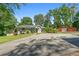 Charming home features a large driveway, lush landscaping, and a red barn in the background at 312 Flat Shoals Church Rd, Stockbridge, GA 30281
