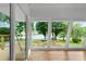 Sunroom with wood floors and many large windows with views of a deck and the lake beyond at 312 Flat Shoals Church Rd, Stockbridge, GA 30281