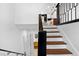 Bright foyer showcases stylish stairs, leading to the kitchen and bathroom featuring modern fixtures at 6660 Hidden Brook Trl, Atlanta, GA 30349