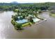Aerial view shows community amenities: tennis courts, pool, clubhouse situated on a lake at 7435 Woodruff Way, Stone Mountain, GA 30087