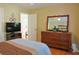 Comfortable bedroom featuring natural light, hardwood floors, and a classic wooden dresser with decorative mirror at 7435 Woodruff Way, Stone Mountain, GA 30087