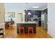 An open kitchen features an island, stainless appliances, granite countertops, and dark cabinets at 7435 Woodruff Way, Stone Mountain, GA 30087