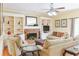 Comfortable living room featuring built-in bookshelves, a brick fireplace, and a ceiling fan at 7435 Woodruff Way, Stone Mountain, GA 30087