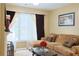 Comfortable living room featuring a fireplace, large windows, and a chaise sectional couch at 7435 Woodruff Way, Stone Mountain, GA 30087