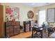 Home office features wood floors, a ceiling fan, a large window, and rustic furnishings at 7435 Woodruff Way, Stone Mountain, GA 30087