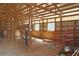 Interior view of the barn's exposed wooden beams, metal siding, and dirt floors at 75 Price Dr, Locust Grove, GA 30248