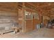 Barn interior with wooden horse stalls and machinery; some clutter on the floor at 75 Price Dr, Locust Grove, GA 30248