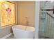 Luxurious bathroom with a standalone tub, a glass-enclosed shower, and a stained glass window at 75 Price Dr, Locust Grove, GA 30248